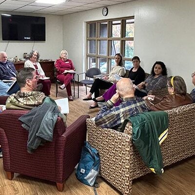 A group of older patients sit in a clinic. 